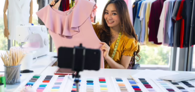 belleza vlogger de moda femenina presentando vestido al móvil y mostrando ropa venta online live streaming